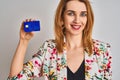 Redhead caucasian business woman holding credit card over isolated background with a happy face standing and smiling with a Royalty Free Stock Photo