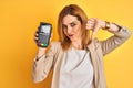 Redhead caucasian business woman holding point of sale terminal over isolated background with angry face, negative sign showing Royalty Free Stock Photo