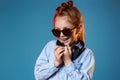 redhead child girl in sunglasses and wireless headphones
