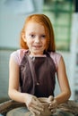 Redhead Child sculpts from clay pot. workshop on modeling on potter`s wheel. Royalty Free Stock Photo