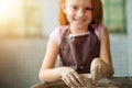 Redhead Child sculpts from clay pot. workshop on modeling on potter`s wheel. Royalty Free Stock Photo