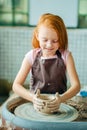 Redhead Child sculpts from clay pot. workshop on modeling on potter`s wheel. Royalty Free Stock Photo