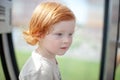 Redhead child thinks and looks into the void