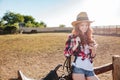 Redhead cowgirl using mobile phone while standing at ranch fence Royalty Free Stock Photo