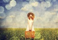Redhead enchantress with suitcase at spring rapeseed field. Royalty Free Stock Photo