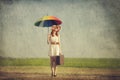 Redhead enchantress with umbrella and suitcase at spring country