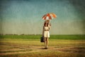 Redhead enchantress with umbrella and suitcase at spring country Royalty Free Stock Photo