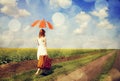 Redhead enchantress walking near rapeseed field. Royalty Free Stock Photo