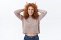 Redhead evil. Cheerful sassy attractive woman with red curly hair, hold hands behind head showing horns, being stubborn