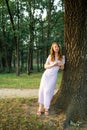 Redhead girl in deep woods posing near tree Royalty Free Stock Photo
