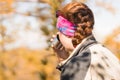 Redhead girl drinks tea from a thermos in autumn in the mountain