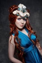 Redhead girl fabulous look, blue long dress, bright makeup and big eyelashes. Mysterious fairy woman with red hair. Big eyes Royalty Free Stock Photo