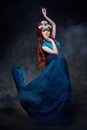 Redhead girl fabulous look, blue long dress, bright makeup and big eyelashes. Mysterious fairy woman with red hair. Big eyes Royalty Free Stock Photo