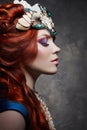 Redhead girl fabulous look, blue long dress, bright makeup and big eyelashes. Mysterious fairy woman with red hair. Big eyes Royalty Free Stock Photo