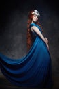 Redhead girl fabulous look, blue long dress, bright makeup and big eyelashes. Mysterious fairy woman with red hair. Big eyes Royalty Free Stock Photo