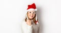 Redhead girl with freckles shows yes, behaved well and receives a gift from Santa Claus, isolated on a white background