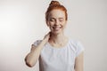 Redhead girl with hair bun and freckles isolated over grey background Royalty Free Stock Photo