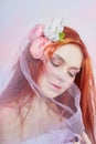 Redhead girl in light airy colored dress sits on the floor white background. Beautiful flowers in girl hair. Romantic woman Royalty Free Stock Photo