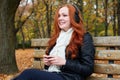 Redhead girl listen music in city park, fall season Royalty Free Stock Photo