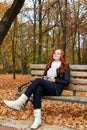 Redhead girl listen music in city park, fall season Royalty Free Stock Photo