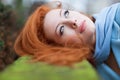 Redhead girl looking up lying down on green Royalty Free Stock Photo