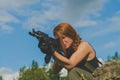 Redhead girl military aim from the weapon Royalty Free Stock Photo