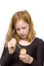 Redhead girl is painting an egg holder Royalty Free Stock Photo