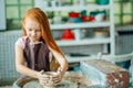 Redhead Child sculpts from clay pot. workshop on modeling on potter`s wheel. Royalty Free Stock Photo