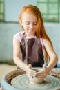 Redhead Child sculpts from clay pot. workshop on modeling on potter`s wheel. Royalty Free Stock Photo