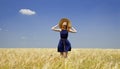 Redhead girl at spring wheat field. Royalty Free Stock Photo