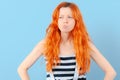 Redhead girl squints and frowns. Doubt, choice and suspicion