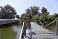 Redhead girl staying on a wooden dock above Danube river near trees. Royalty Free Stock Photo