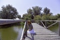 Redhead girl staying on a wooden dock above Danube river near trees. Royalty Free Stock Photo