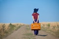 Redhead girl with suitcase at countryside road Royalty Free Stock Photo