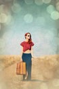 Redhead girl with suitcase at countryside road Royalty Free Stock Photo