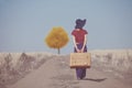 Redhead girl with suitcase at countryside road Royalty Free Stock Photo