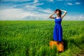 Redhead girl with suitcase standing at wheat field Royalty Free Stock Photo