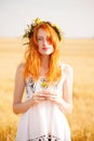 Redhead girl at summer wheat field Royalty Free Stock Photo