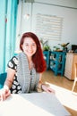 Redhead girl in a turquoise quirky coffee shop displaying croissants