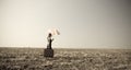 Redhead girl with umbrella at windy field. Royalty Free Stock Photo