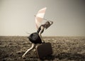 Redhead girl with umbrella at windy field. Royalty Free Stock Photo