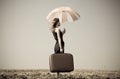 Redhead girl with umbrella at windy field. Royalty Free Stock Photo