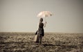 Redhead girl with umbrella at windy field. Royalty Free Stock Photo