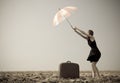 Redhead girl with umbrella at windy field. Royalty Free Stock Photo