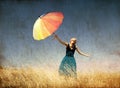 Redhead girl with umbrella at windy grass meadow. Royalty Free Stock Photo