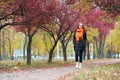 Redhead girl walk on pathway in city park, fall season Royalty Free Stock Photo