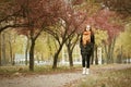 Redhead girl walk on pathway in city park, fall season Royalty Free Stock Photo