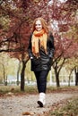 Redhead girl walk on pathway in city park, fall season Royalty Free Stock Photo