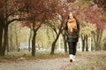 Redhead girl walk on pathway in city park, fall season Royalty Free Stock Photo