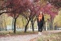 Redhead girl walk on pathway in city park, fall season Royalty Free Stock Photo